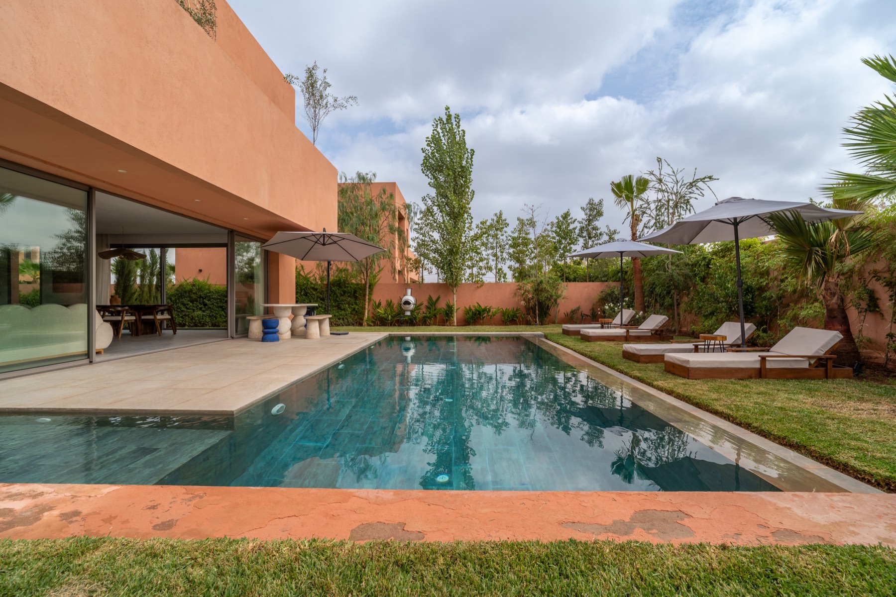 Long pool lined with sun loungers