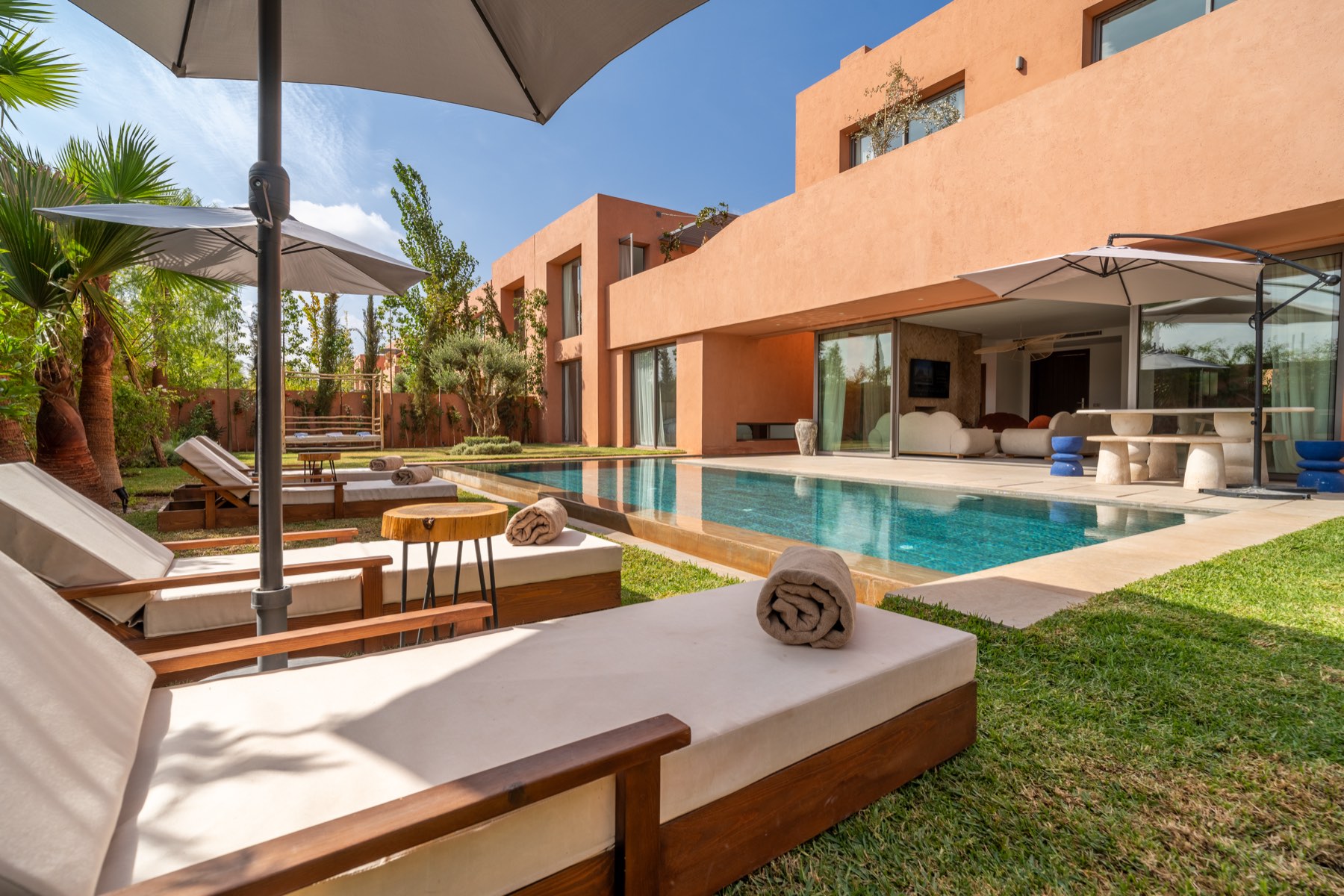 Pool terrace with sun loungers and the villa's terracotta façade
