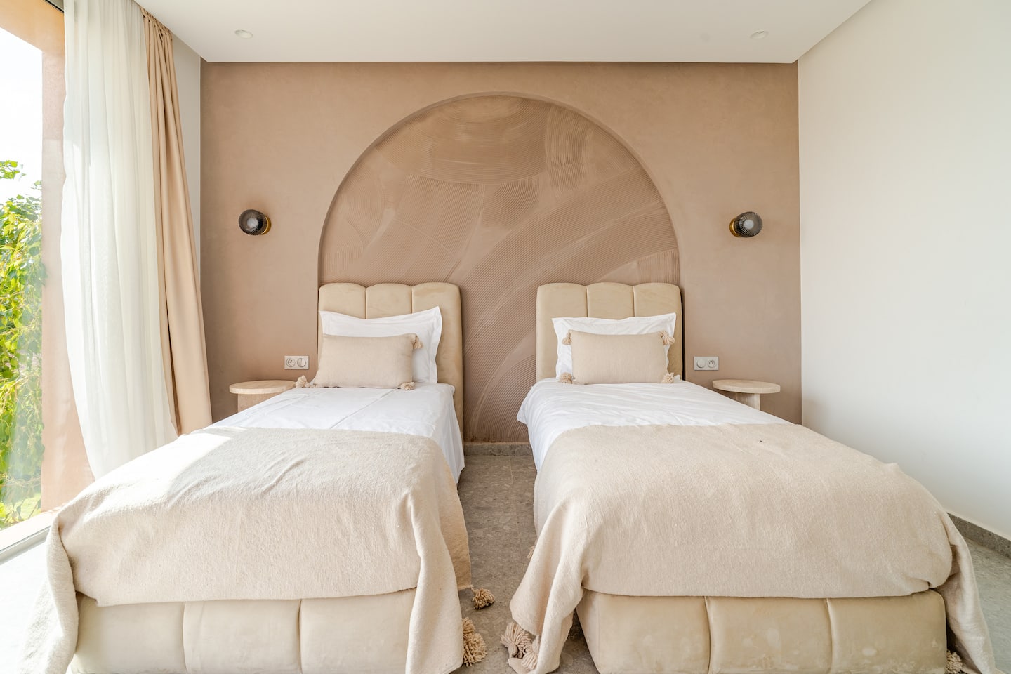 Twin bedroom with two single beds under a plaster arch