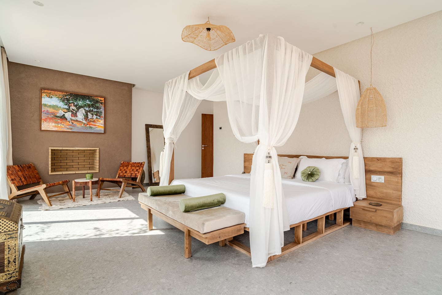 Bedroom with a canopy bed, reading chairs and a painting